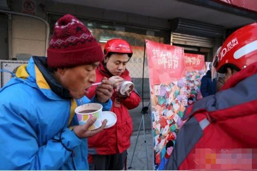     在营业部工作的达达快递员朱新卫和大家围在一起喝着粥。  